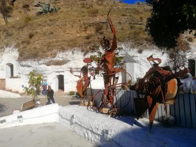 Monumentos en hierro frente a un grupo de cuevas